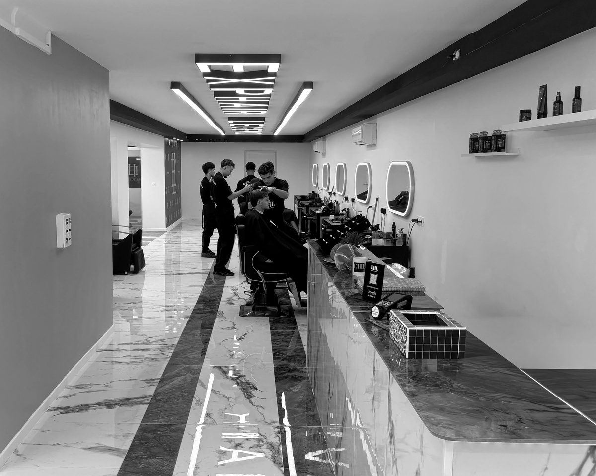 Intérieur du barbershop Exp' Hair Legend avec fauteuils et miroirs lumineux